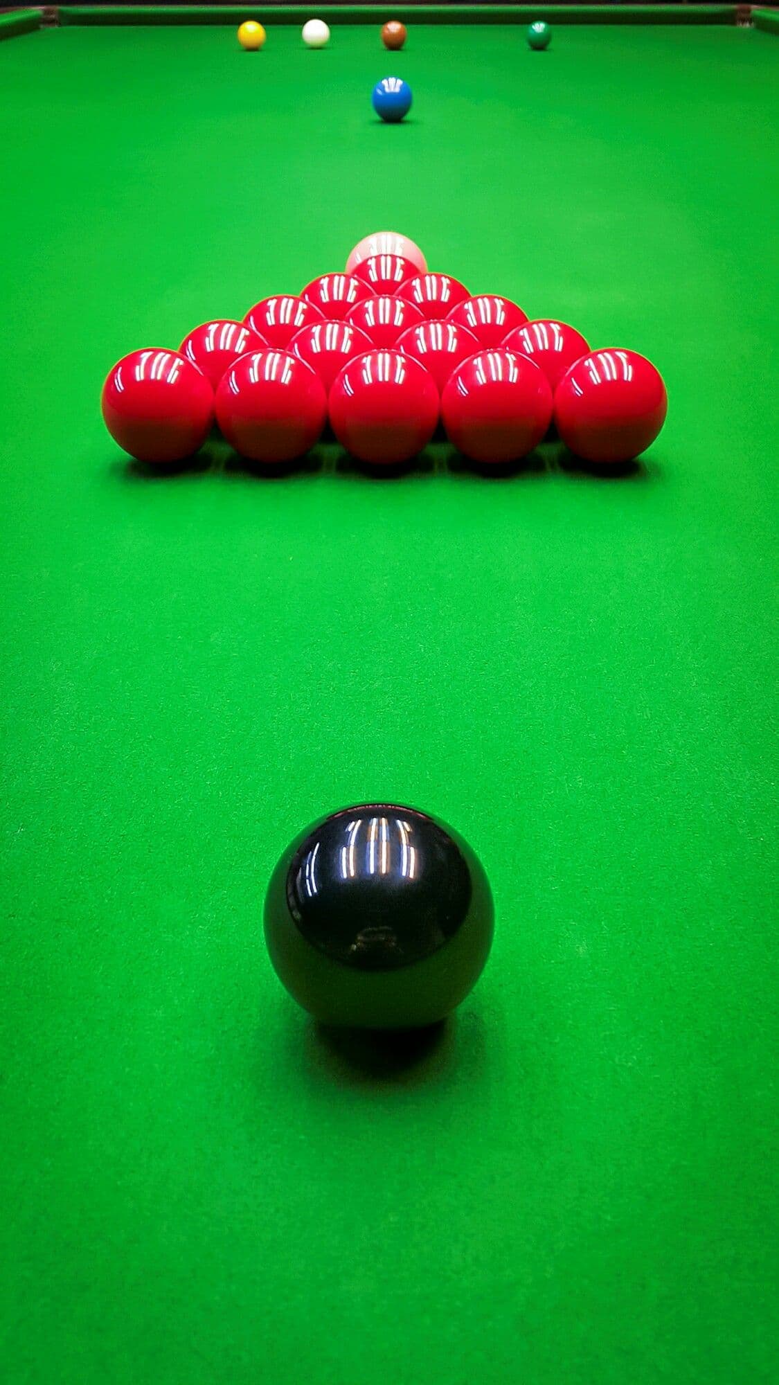 Racked reds and the black ball on a snooker table